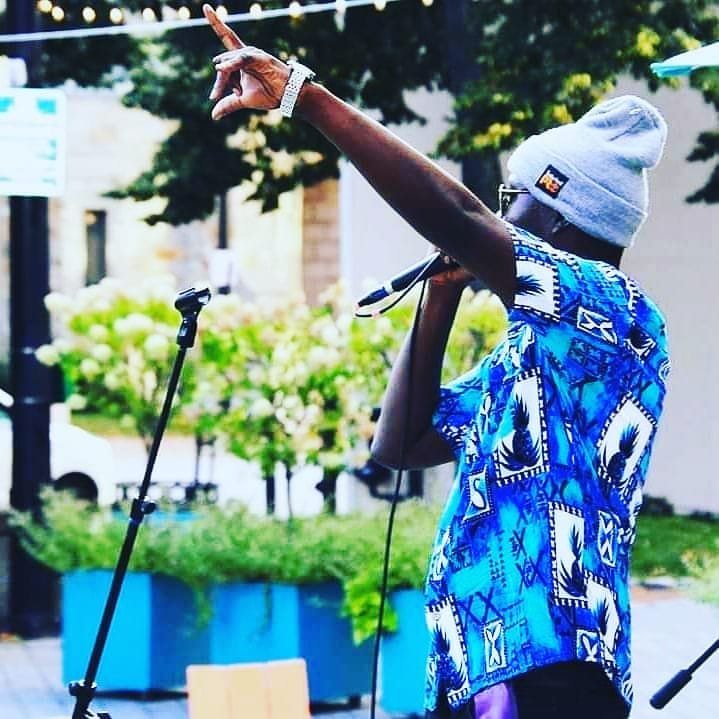 African Dundada performing outdoors — blue African shirt